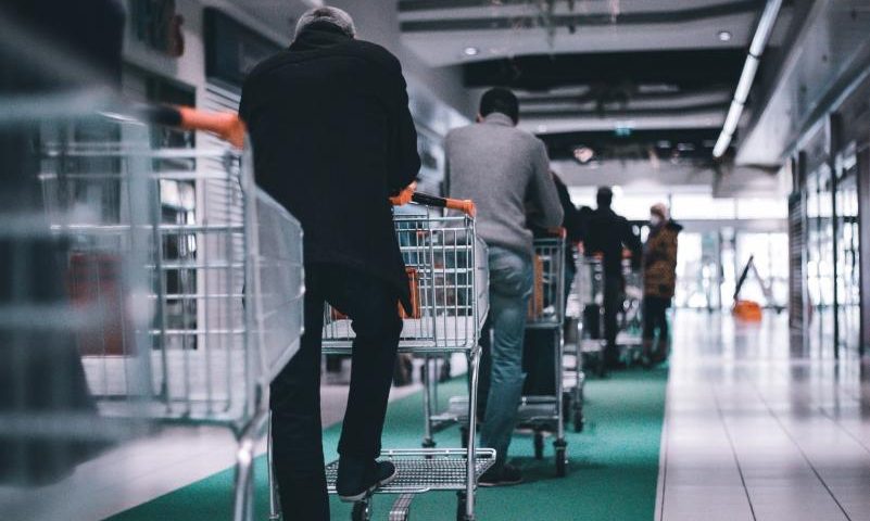 Queue management systems, people waiting with their shopping carts in a queue